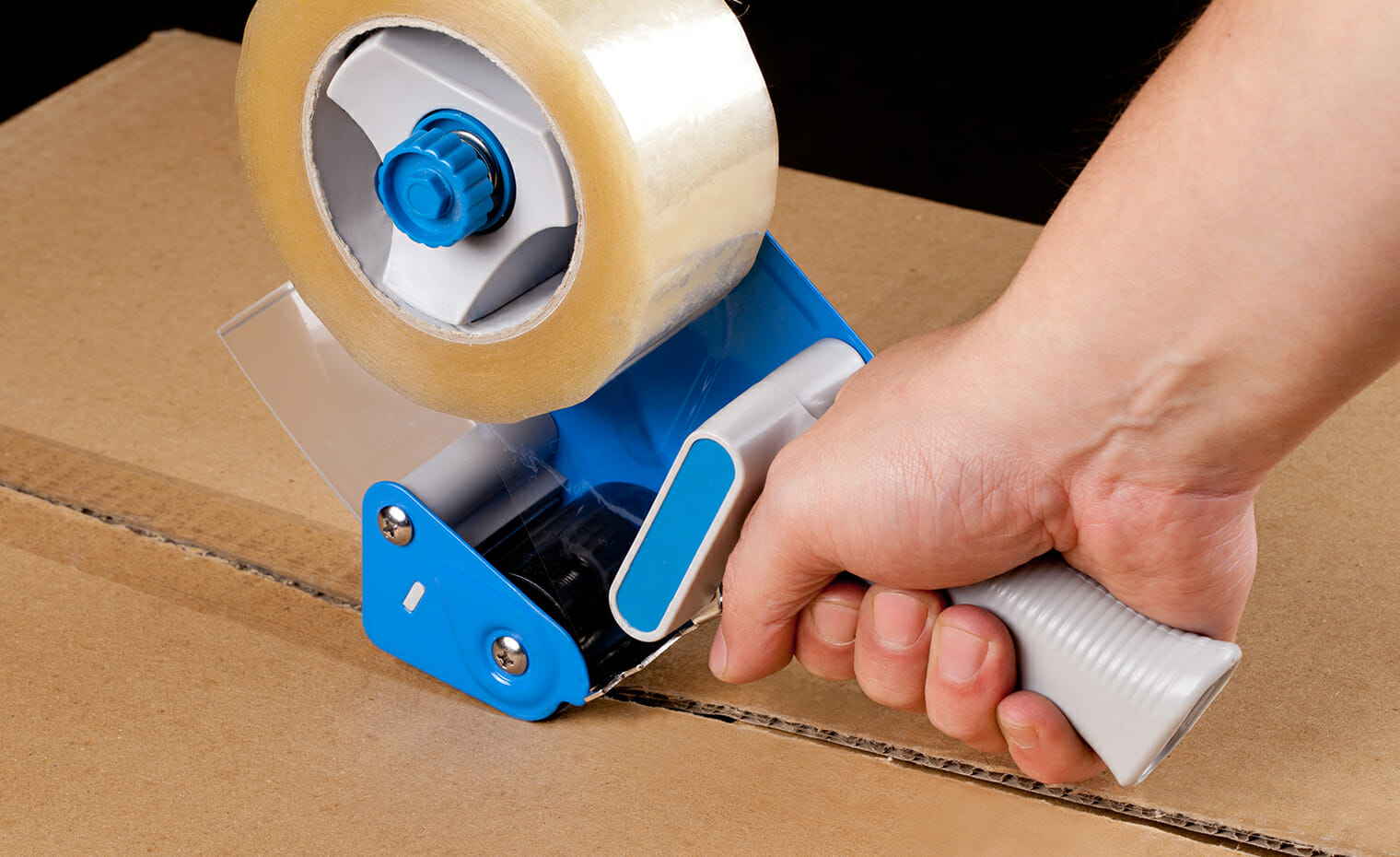 close up image of a tape gun with clear packing tape
